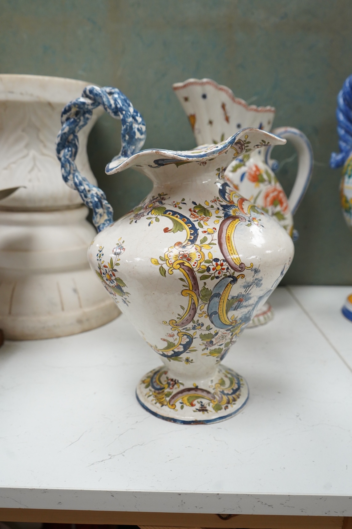 Two large French faience jugs and a vase, and a Talavera twin handled urn/vase, 44cm high